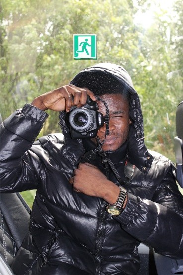 Boy holding camera taking photo in black jacket