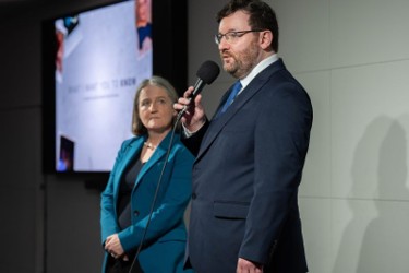 Cllr Paul Kelly standing on stage with a microphone