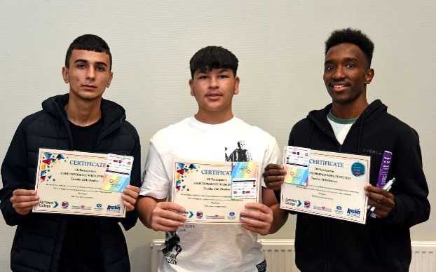 Three boys standing with certificates